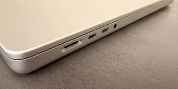 Silbernes MacBook auf einer dunklen Tischplatte, Blick auf MagSafe-Anschluss, zwei USB-C-Anschlüsse und Kopfhörerbuchse – Symbolbild zum Notebook-Markt 2027