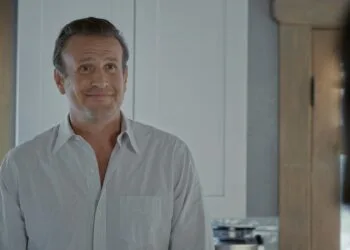 Vor Shrinking Staffel 4: Jason Segel als Jimmy in einer früheren Folge, lächelnd in einer Küche, rechts unscharf eine Person im Vordergrund