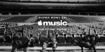 Super Bowl LXI Jay-Z: Der Rapper sitzt in Tarnkleidung auf einer leeren Stadiontribüne zwischen schwarzen Ziegen, darüber der Schriftzug der Apple Music Halftime Show