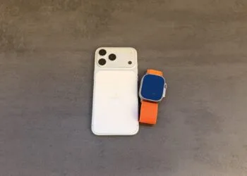 Taptic Engine Patentstreit: iPhone in Weiß mit Dreifachkamera von hinten, daneben eine Apple Watch Ultra mit orangefarbenem Alpine Loop auf grauem Untergrund